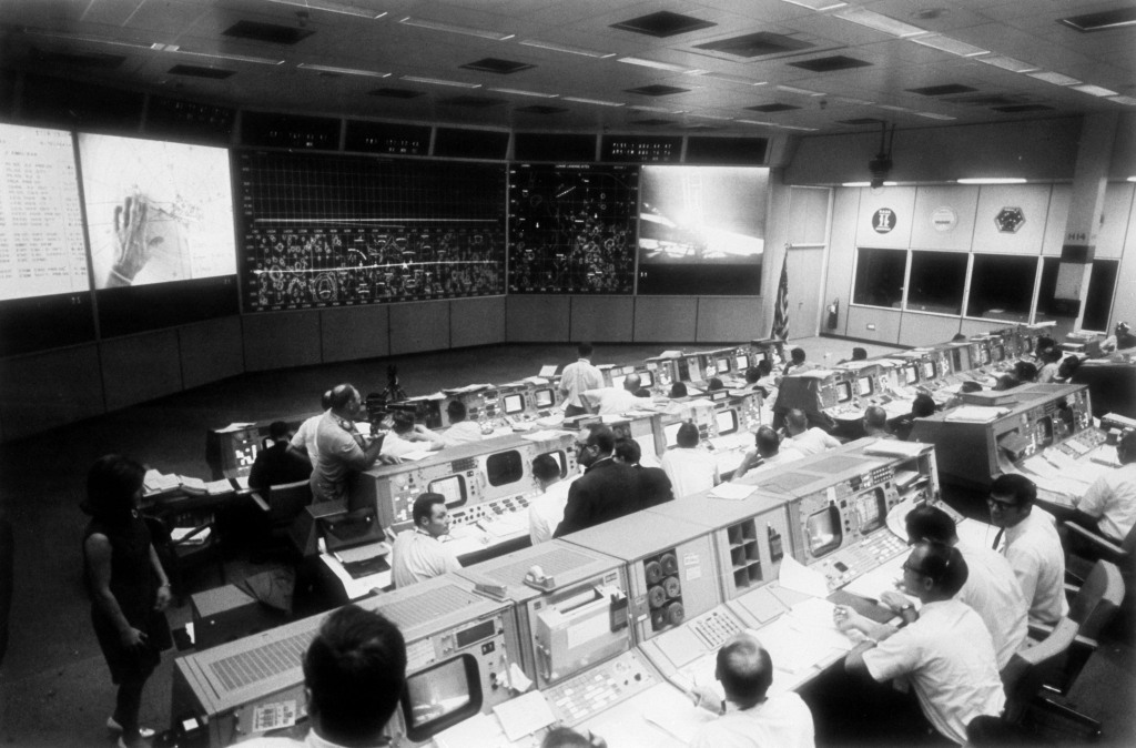 Overall view of Mission Control Center with dozens of people sitting at computer terminals